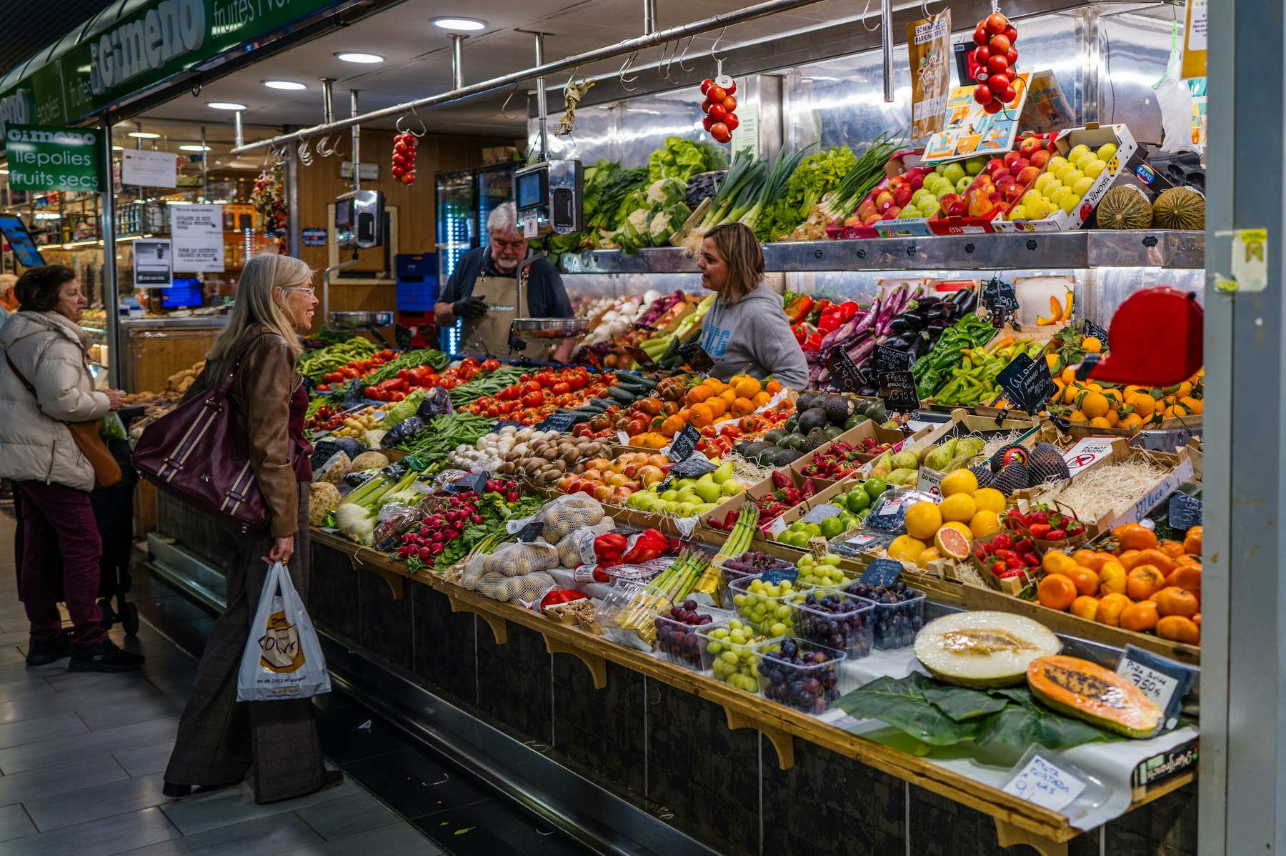 Customers and vendors at a vibrant produce market stall
